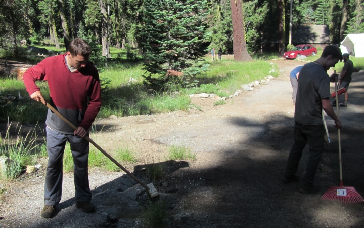 Outward Bound students use gardening tools to work on a trail during a service day